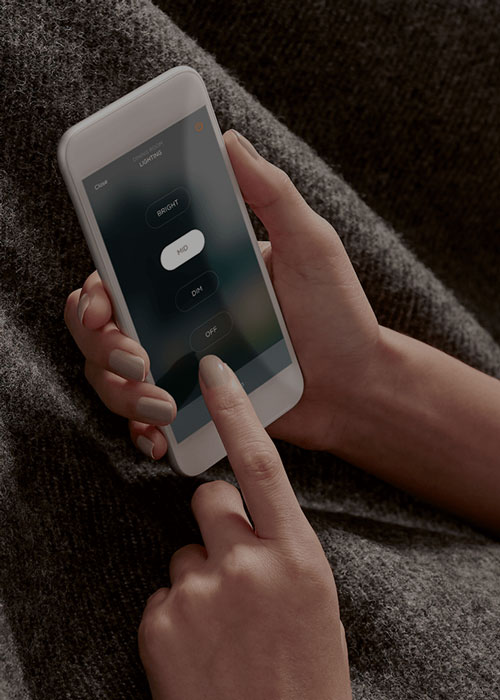 Hand holding a smartphone with home automation app.