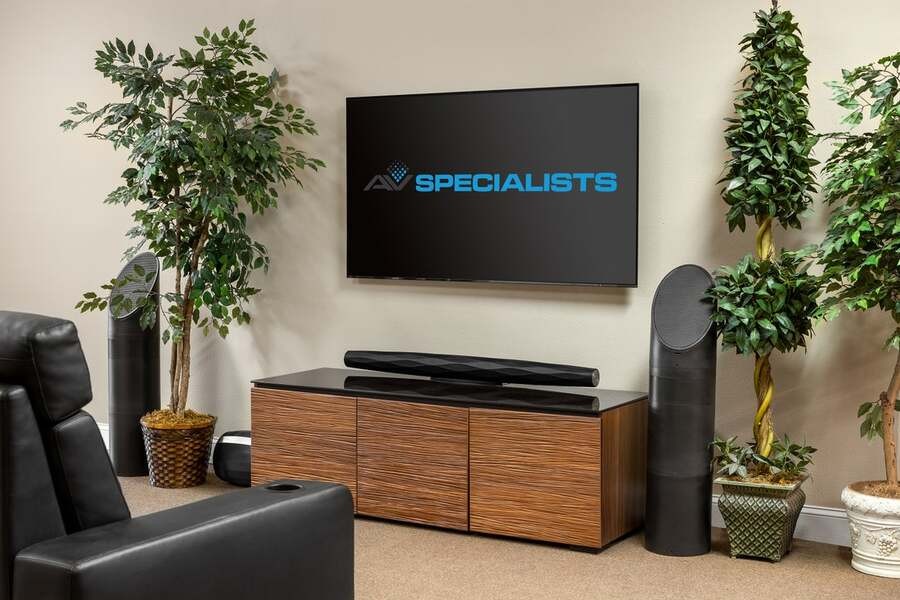 A family room with a modern TV screen displaying AV Specialist’s logo.