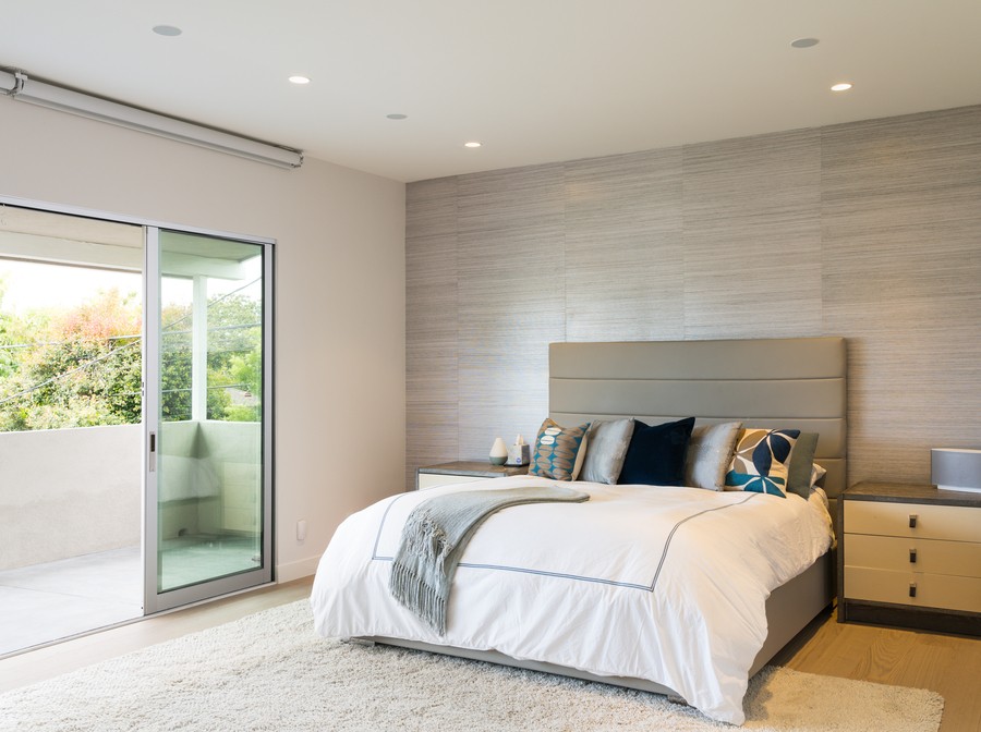 Tunable lighting fixtures in a bedroom with a queen size bed  tuned to a bright midday setting. 