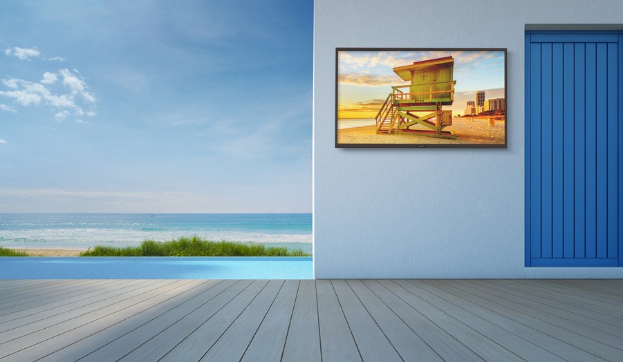 A Sunbrite TV with the ocean and an infinity pool in the background. 