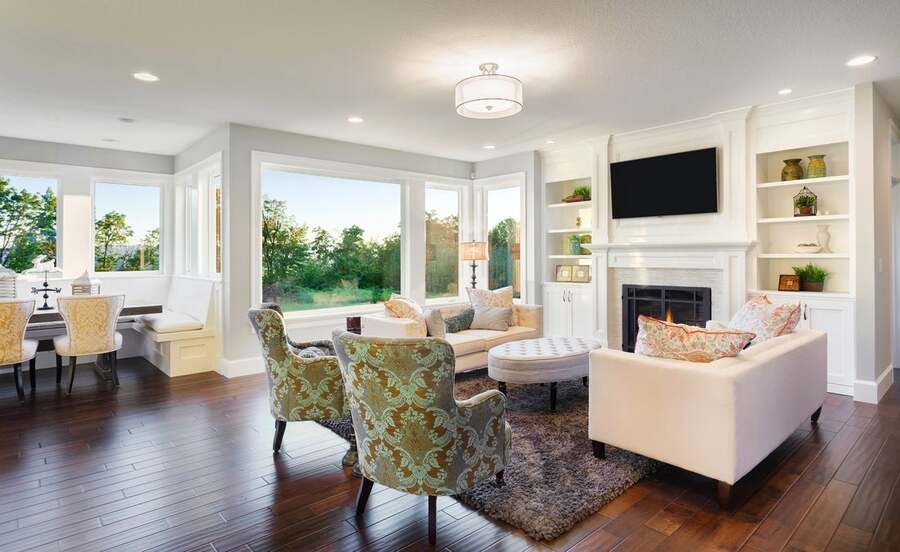 A luxurious living room overseeing the garden, with recessed lighting fixtures in the ceiling.