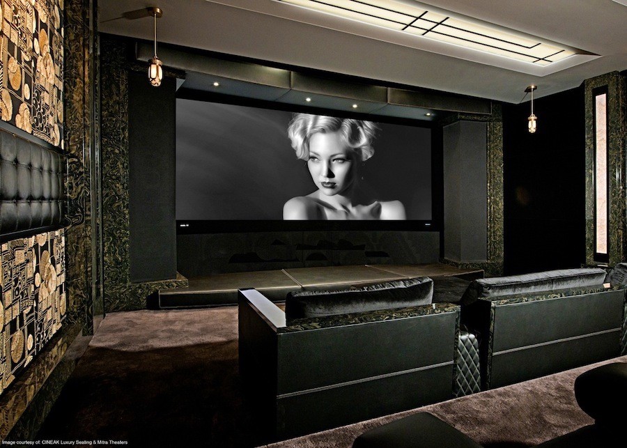 luxury home theater with pendant lights, plush seating, and a projection screen showing a woman