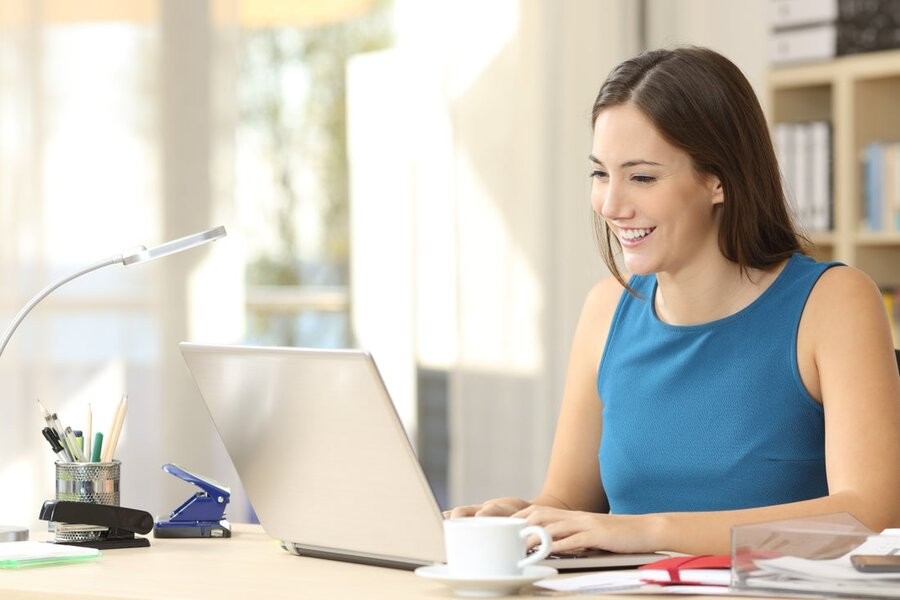 A woman at her desk using a laptop.