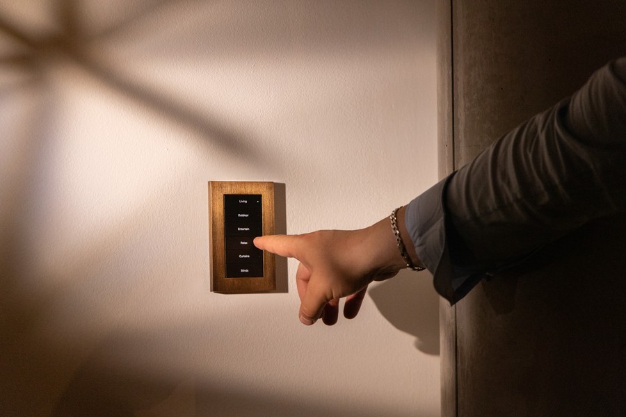 Hand pressing a Control4 wall keypad.