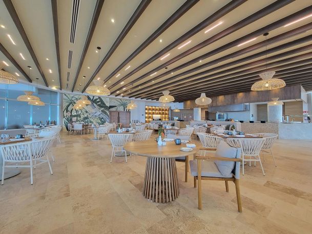 Spacious restaurant dining area with wooden beams and woven lights