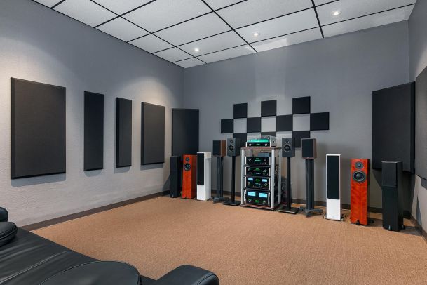 Audio demo room with multiple floor speakers and stacked amplifiers