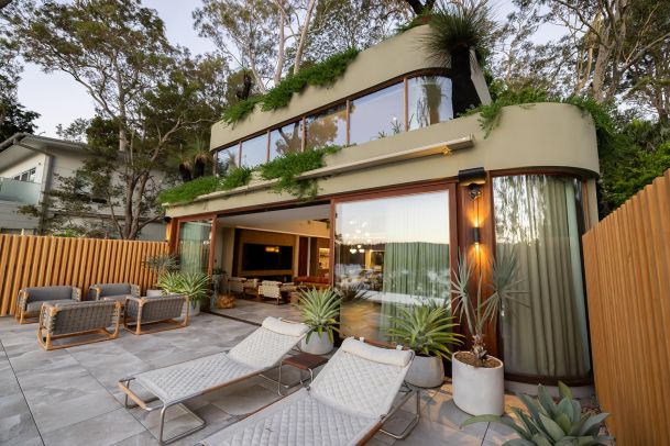 Modern house with terrace, outdoor seating, and rooftop greenery