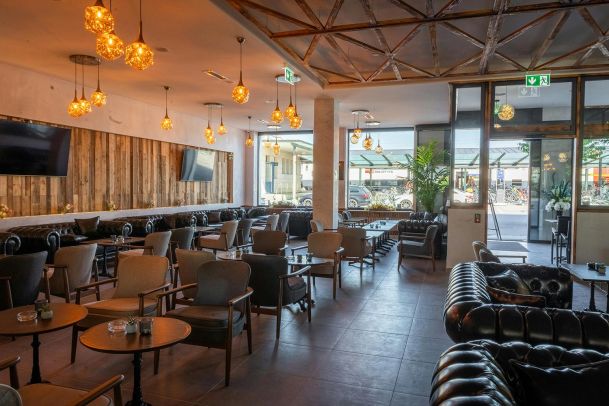 Outdoor entertainment area with large wall-mounted TV and fire pits