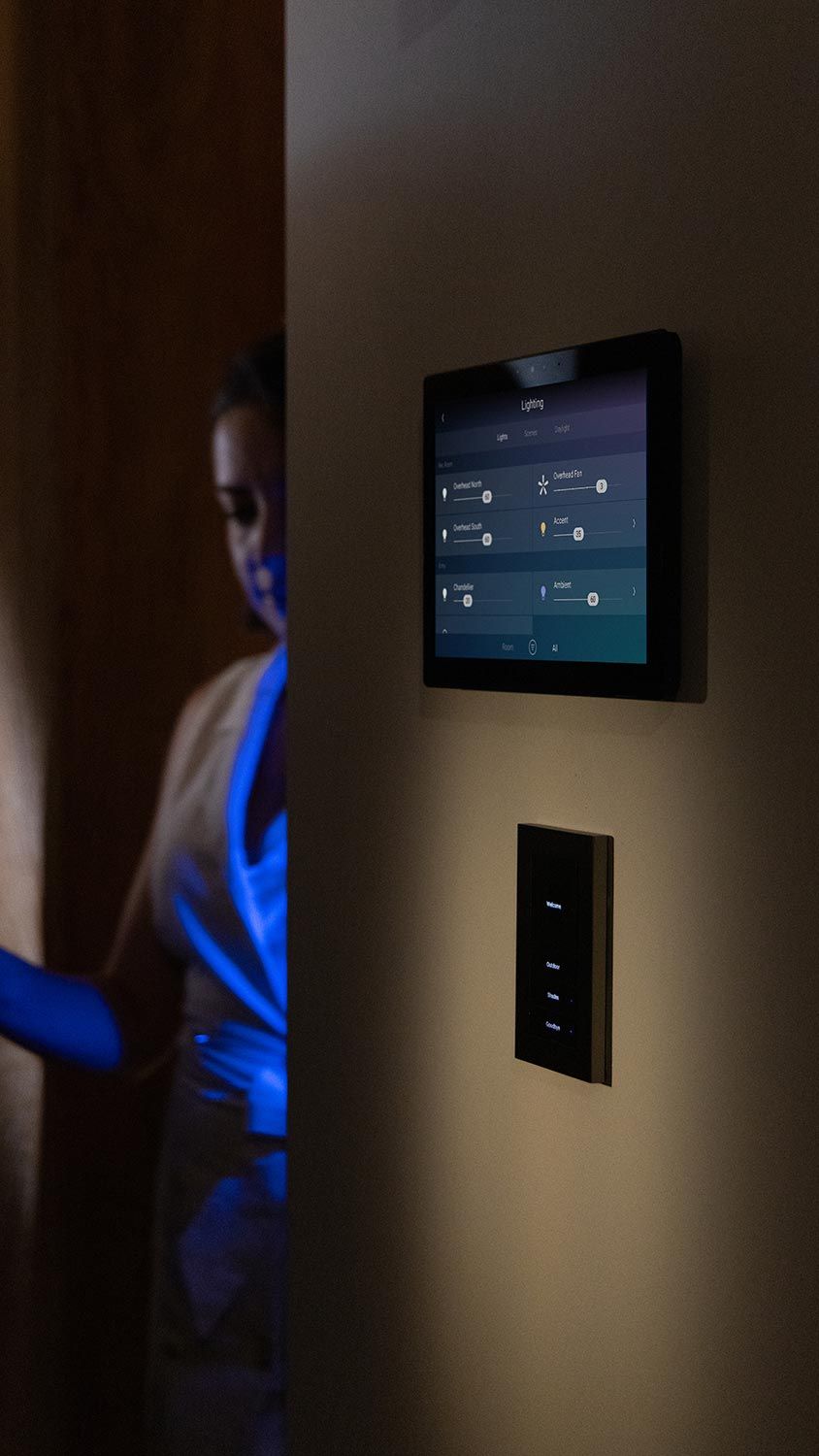 Woman in dim room adjusting smart home lighting controls